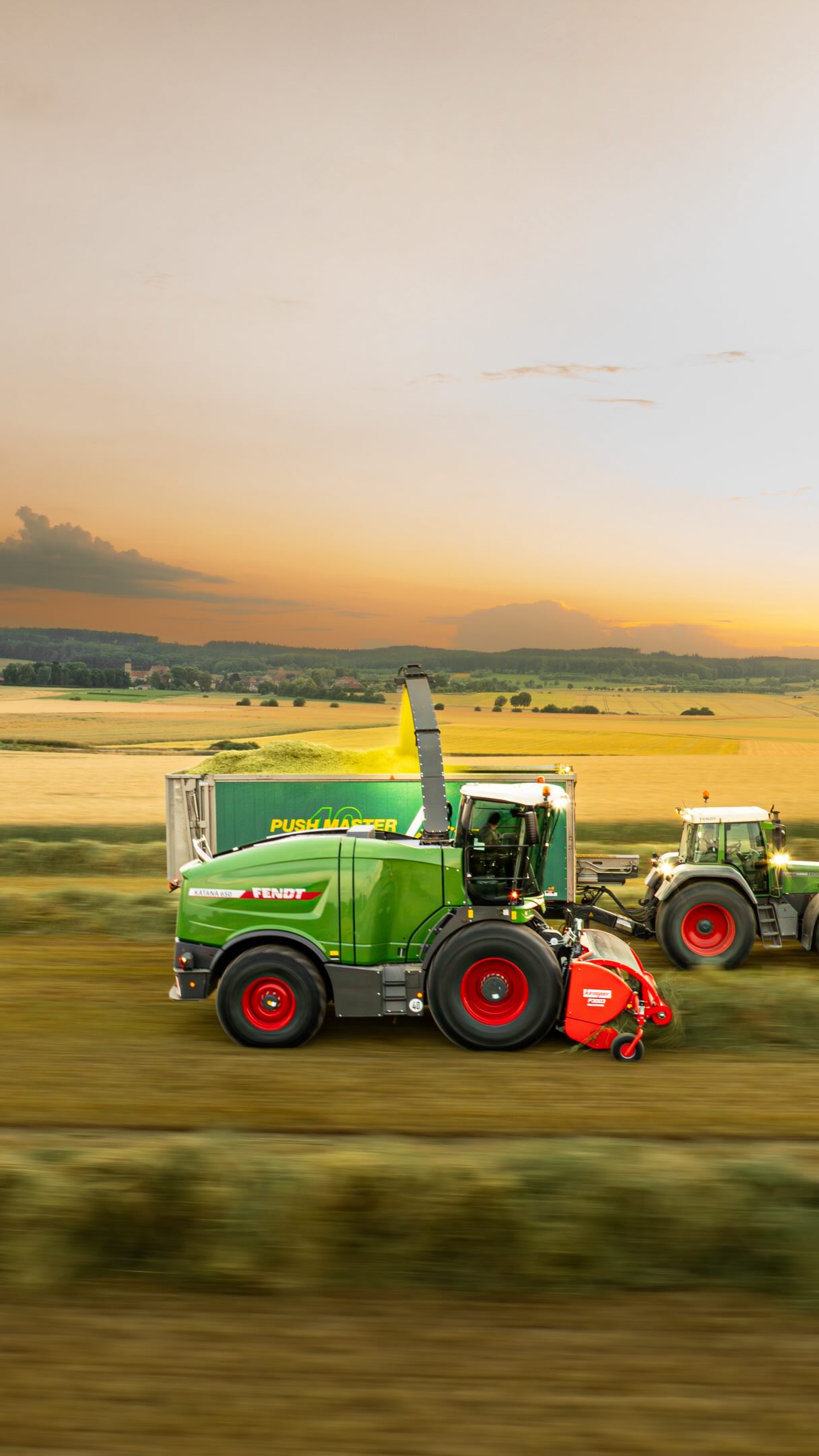 Erntemaschine bei Sonnenuntergang im Feld